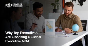 Three business professionals engaged in a discussion at a modern workspace, symbolizing global collaboration and strategic decision-making, aligning with the benefits of a Global Executive MBA