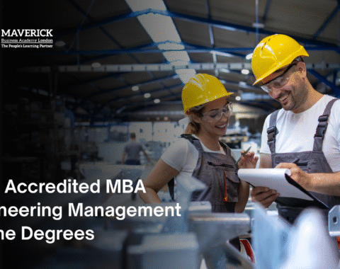 Engineers in safety helmets discussing plans inside a factory, representing accredited online MBA in Engineering Management programs