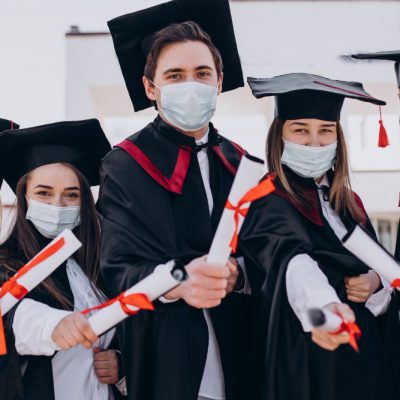 group-students-celebrating-graduation-together-wearing-face-masks